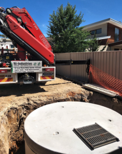 image shows a loose-supplied cast iron grate sits on a rainwater tank before a driveway is poured.